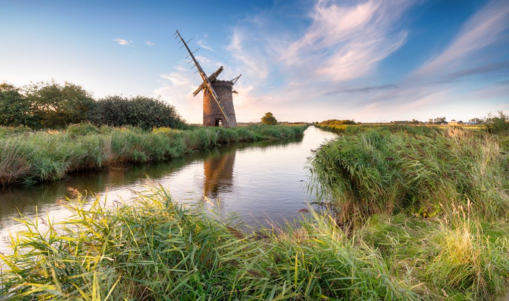 windmill situated on the edge of the water of the fens