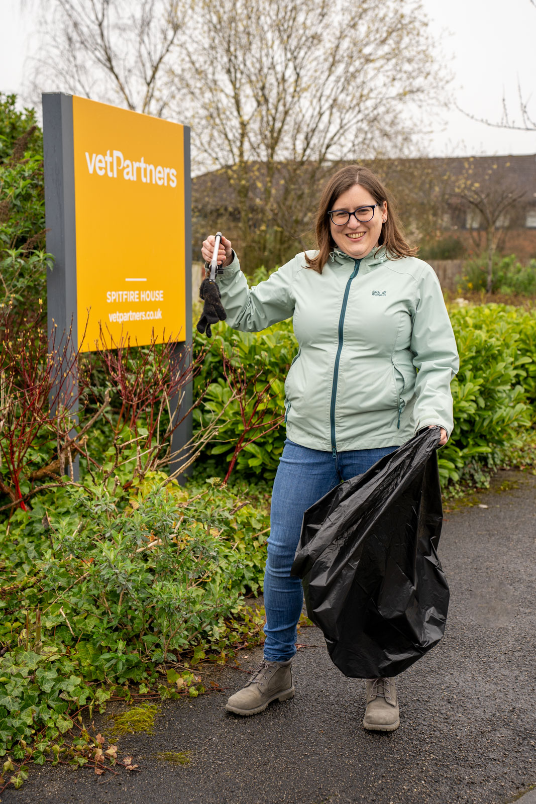 VetPartners Head of ESG, Hannah James, holding a bin liner and litter picker