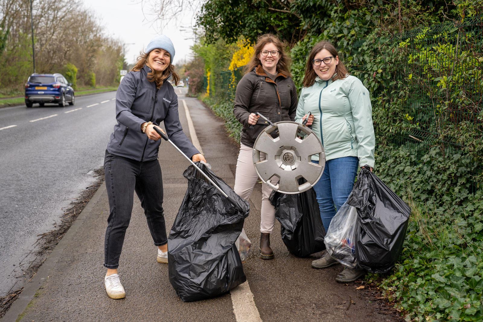 Colleagues holding a hubcap found during the litter pick.