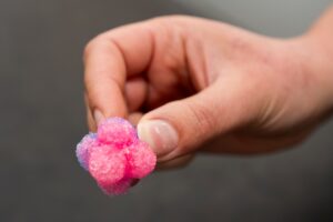 Hand holding a pink ball made out of crystals